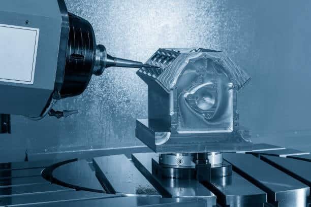 5-axis CNC milling machine machining a complex metal component with angled cutting