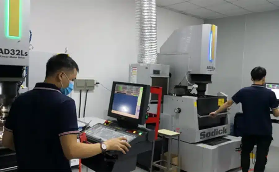 Operator programming a Sodick AAD32Ls linear motor EDM machine for precision mold fabrication.