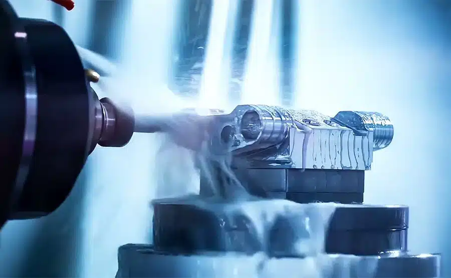 5-axis CNC machine cutting an aluminum alloy component with coolant spray for high-precision machining.