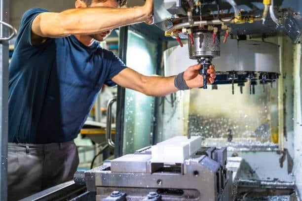 Operator setting up a CNC milling machine for a new machining operation