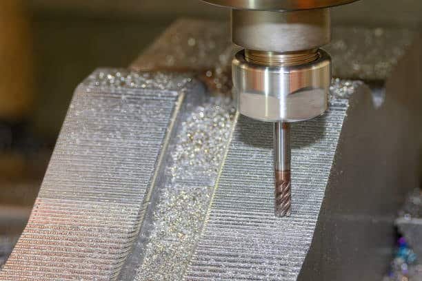 End milling process creating smooth and detailed surface finishes on a metal block