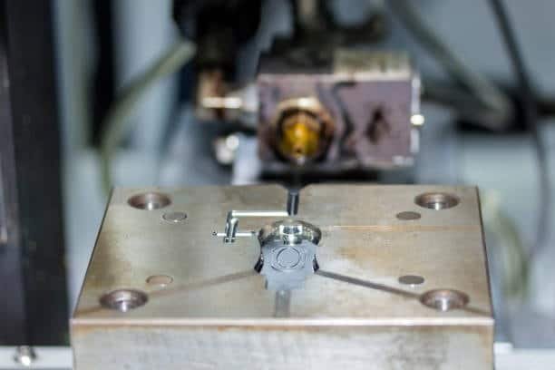 Close-up of injection mold showing hot runner nozzle connection for precise plastic flow.