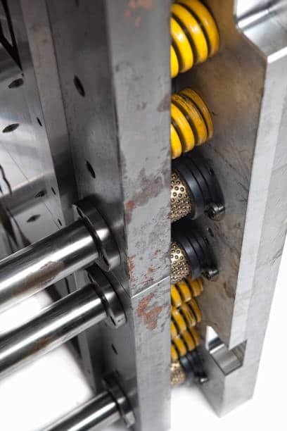 Close-up of hot runner injection mold featuring ejector system and heavy-duty return springs.