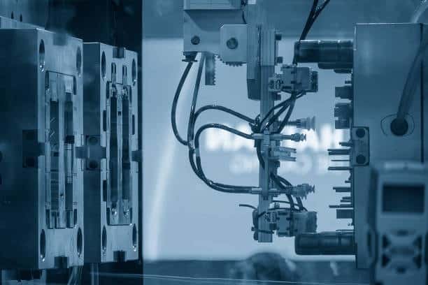 Side-by-side mold setup comparison between hot runner and cold runner systems inside injection molding machines.