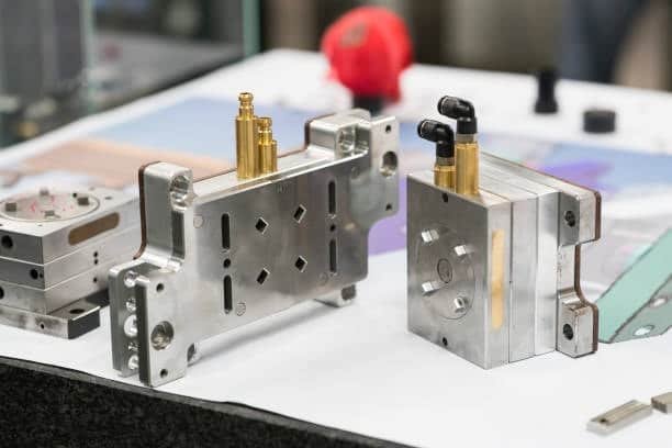 Injection molding die and compression molding tooling displayed for plastic manufacturing processes.
