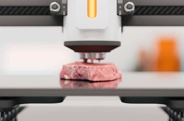 3D food printer depositing layers of meat-like material to form a protein-based steak.
