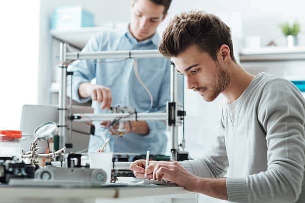 Engineers working on 3D printing design and prototyping using a desktop printer.