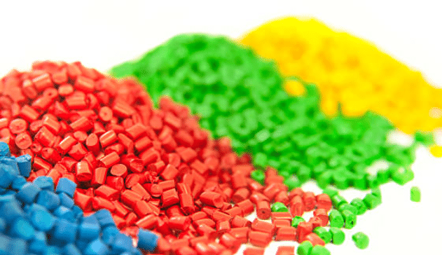 Closeup of red green blue and yellow ABS plastic resin pellets used in molding and extrusion
