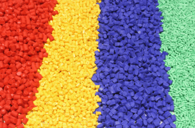Strips of red yellow blue and green ABS plastic pellets showing customized plastic formulations