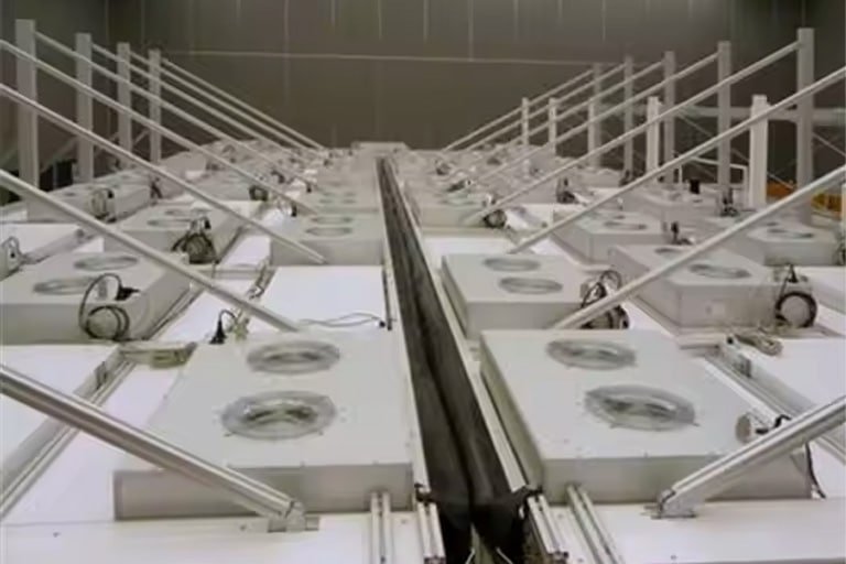 Rows of aluminum parts suspended in an anodizing cleaning bath within an industrial facility.