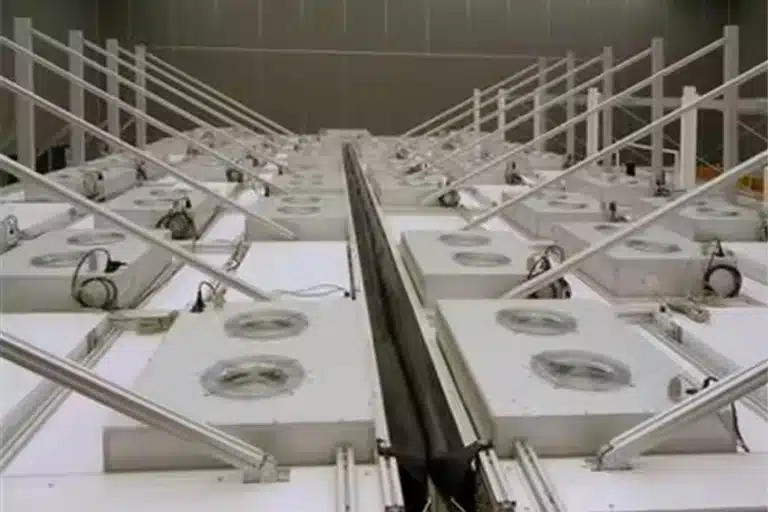 Hàng loạt bộ phận nhôm được treo trong bể làm sạch anodizing bên trong một cơ sở công nghiệp.