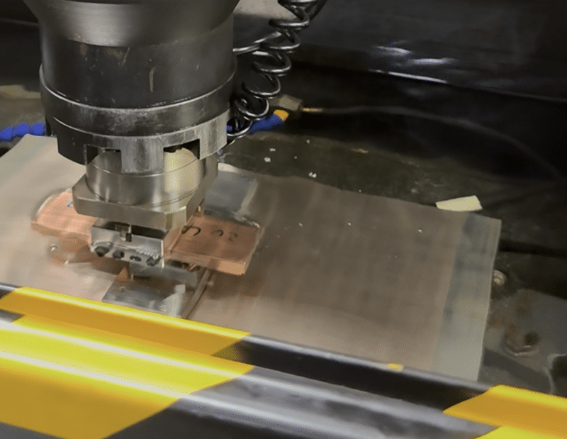 EDM machine cutting metal block with precision electrode head and safety guard