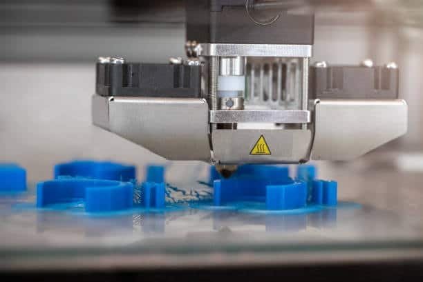 3D printer extruding blue plastic to shape injection mold patterns