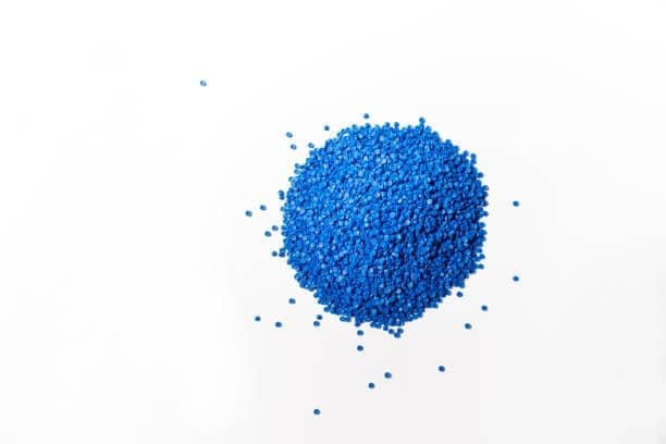 Top view of blue thermoplastic elastomer granules scattered on white background