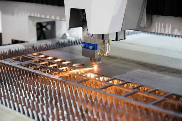 High-power CNC laser machine cutting geometric patterns into a metal sheet with clean edges