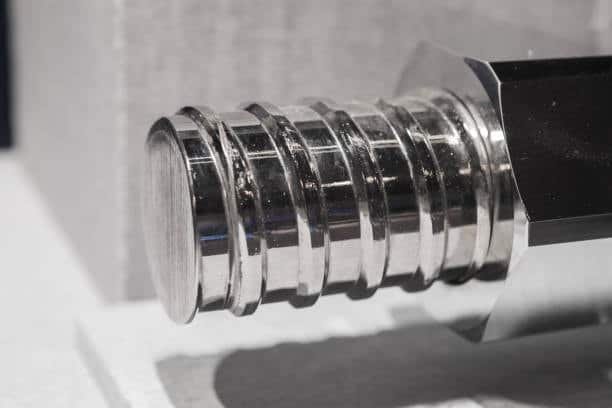 Machined titanium screw component with polished grooves