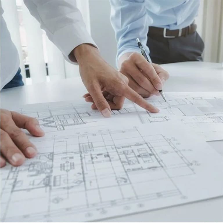 Two engineers reviewing a mold design blueprint, ensuring thorough planning and design accuracy.