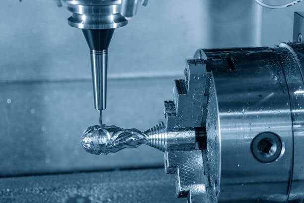 Close-up of 4-axis milling tool cutting intricate geometry on cylindrical part