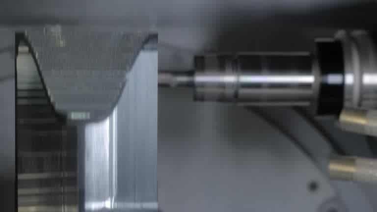 CNC machine conducting climb milling on metallic workpiece