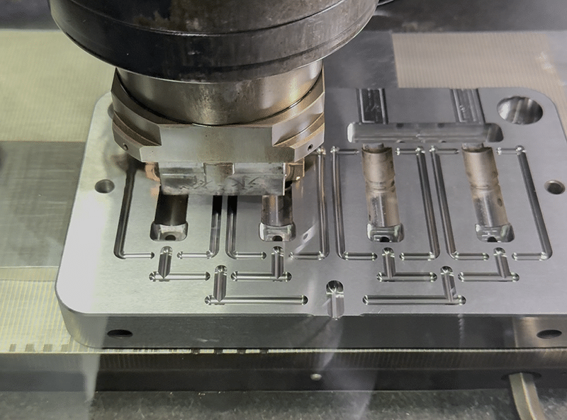 Multi-cavity mold base being machined with EDM for cooling channels and flow paths
