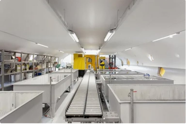 Automated electroplating line with multiple plating tanks and conveyor system in a clean industrial environment.