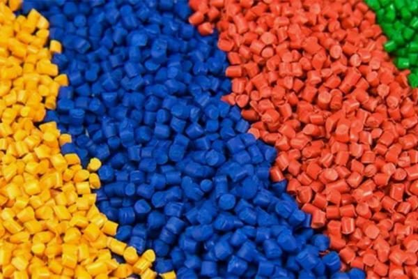 Multi-colored plastic pellets representing common engineering plastics used in precision injection molding, such as ABS, PC, TPU, PA, HDPE, and PP.