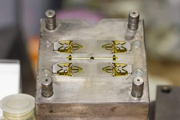 Closeup of mold insert showing runner channels and multiple part cavities