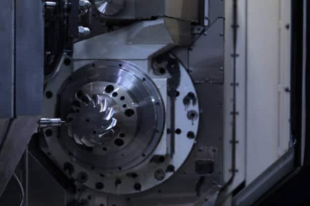 CNC machine dynamically milling a multi-blade impeller with tight tolerance and rotating fixture