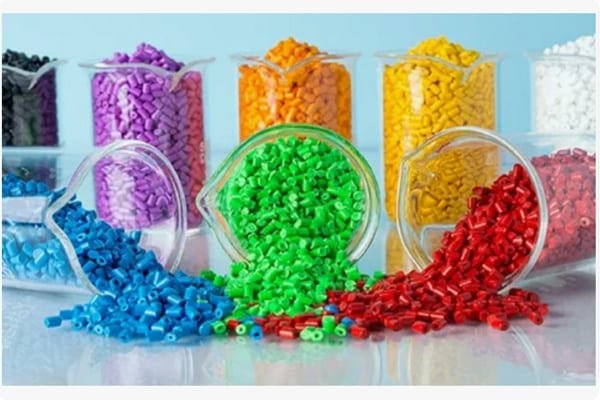 Multiple piles of plastic pellets in various colors, showcasing common general-purpose, engineering, and modified materials used in injection molding.