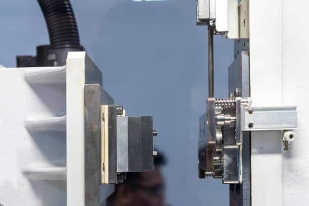 Side view of an open injection mold showing the runner interface