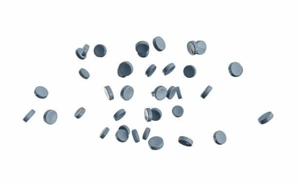 Circular shaped TPE pellets floating in air on white background for elastomer molding use