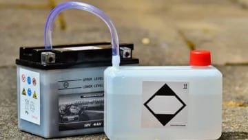 Battery pack and a translucent chemical container side by side, representing multi‐material enclosures for power storage systems.