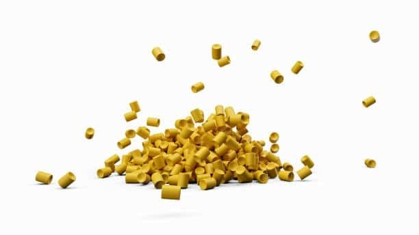 Yellow thermoplastic elastomer resin granules scattered on white background used in flexible part production