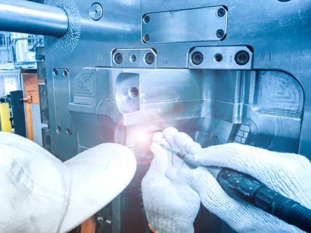 Technician polishing and maintaining injection mold for ABS plastic molding