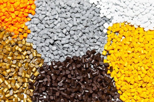 High-resolution image of assorted ABS pellets in brown, gold, and gray, ideal for safe molded components.