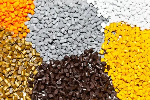 High-resolution image of assorted ABS pellets in brown, gold, and gray, ideal for safe molded components.