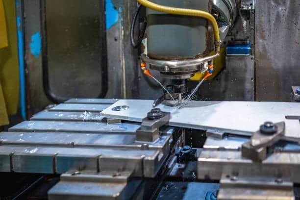 ABS plastic sheet clamped on CNC machine being precisely routed for part manufacturing