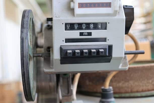 Mechanical feed rate counter measuring material travel in meters for controlled machining