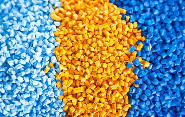 Blue and yellow ASA plastic pellets for injection molding.