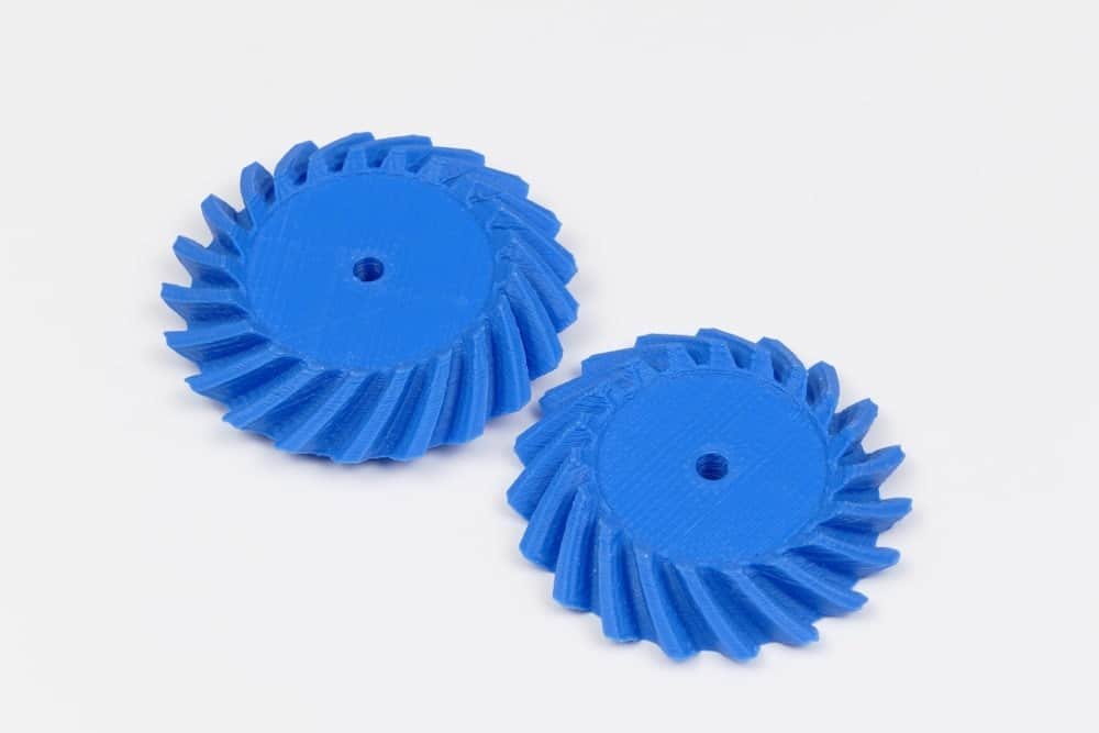 Two blue ASA plastic gears with helical teeth for industrial use.