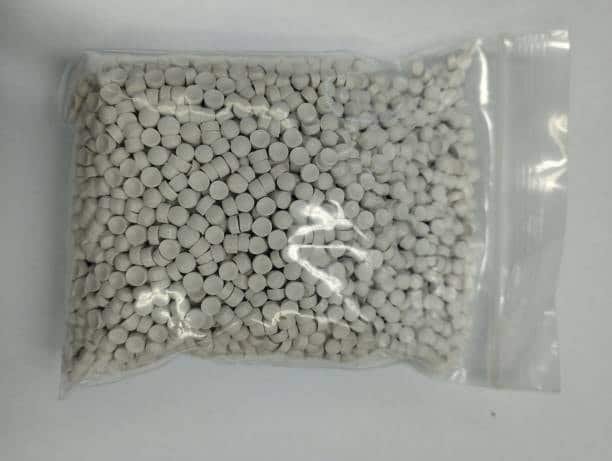 Bag of white ASA plastic pellets for weather-resistant molding.