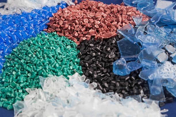 Assorted colorful plastic pellets including ASA for injection molding.