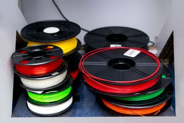A variety of filament spools including polypropylene and polycarbonate, ready for 3D printing.