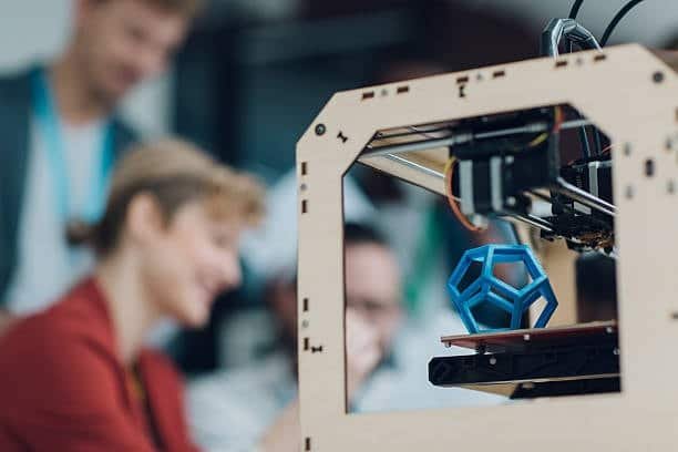 A blue geometric object being 3D printed