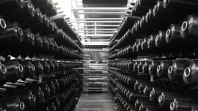 Carbon fiber prepreg reels stored in an organized array for industrial manufacturing