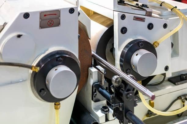 Centerless grinding machine processing a cylindrical metal bar with high accuracy
