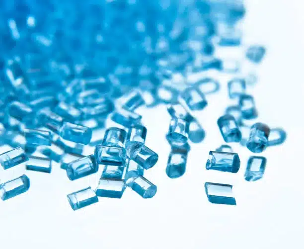 Translucent blue ABS pellets symbolizing non-toxic and recyclable plastic materials.