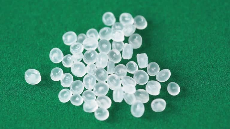 Transparent medical-grade TPE pellets on a green background, suitable for FDA-approved uses.