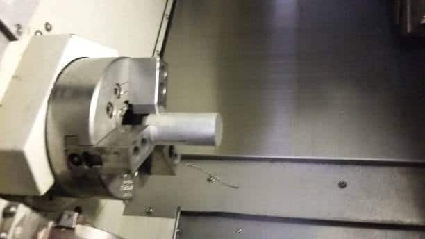 CNC chuck securely clamping cylindrical metal workpiece for turning