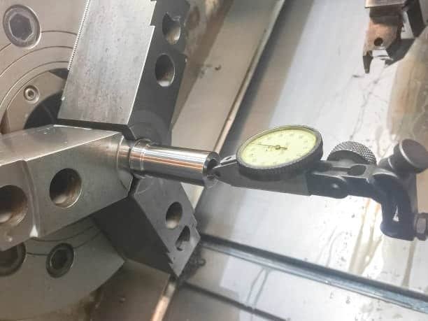 CNC lathe using dial indicator to check machining tolerance